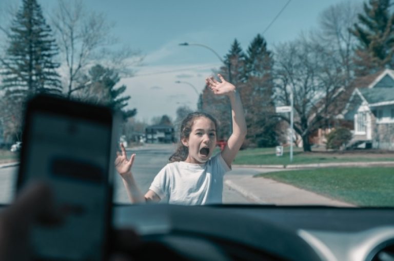 Little girl screaming before being hit by car because driver has cell phone and texting while driving Seen from inside car driver point of view